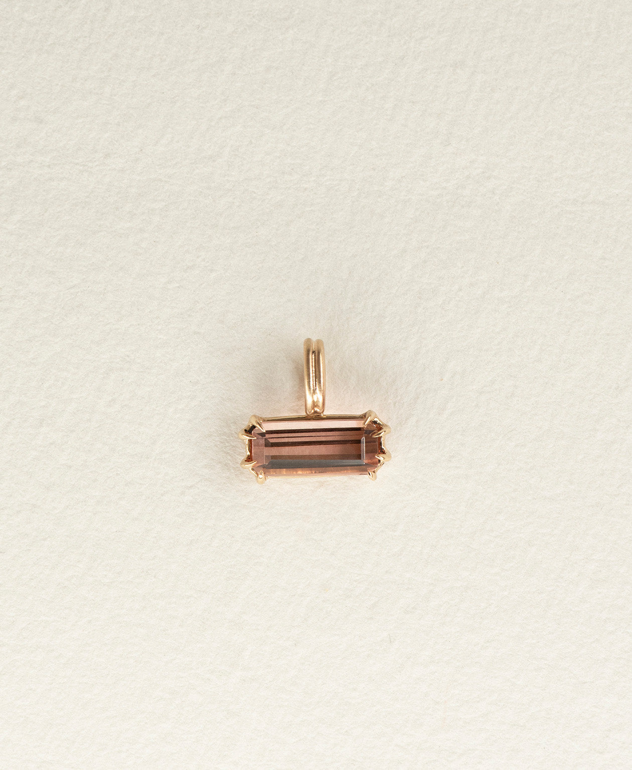 One of a Kind Charm 491 in 9k Yellow Gold featuring an emerald cut pink tourmaline, with a double claw setting.