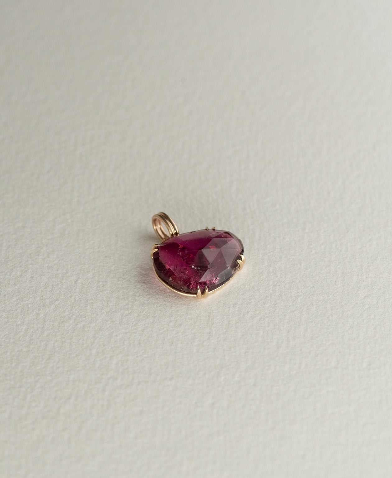Angled view of the One of a Kind Charm 492 in 9k Yellow Gold with a rose cut pink tourmaline.