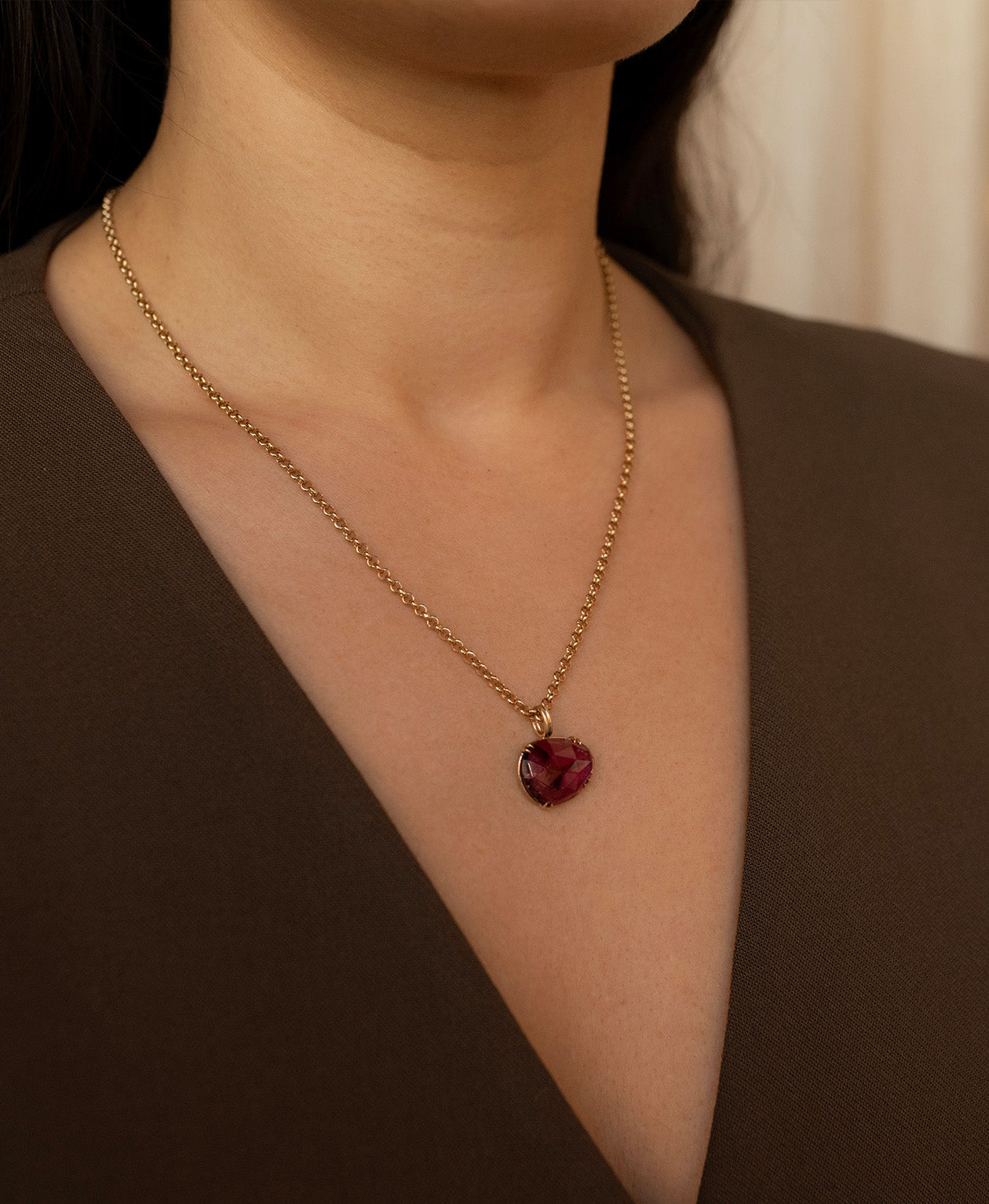 Close up of the One of a Kind Charm 492 with a rose cut pink tourmaline worn by a model on a fine belcher chain.