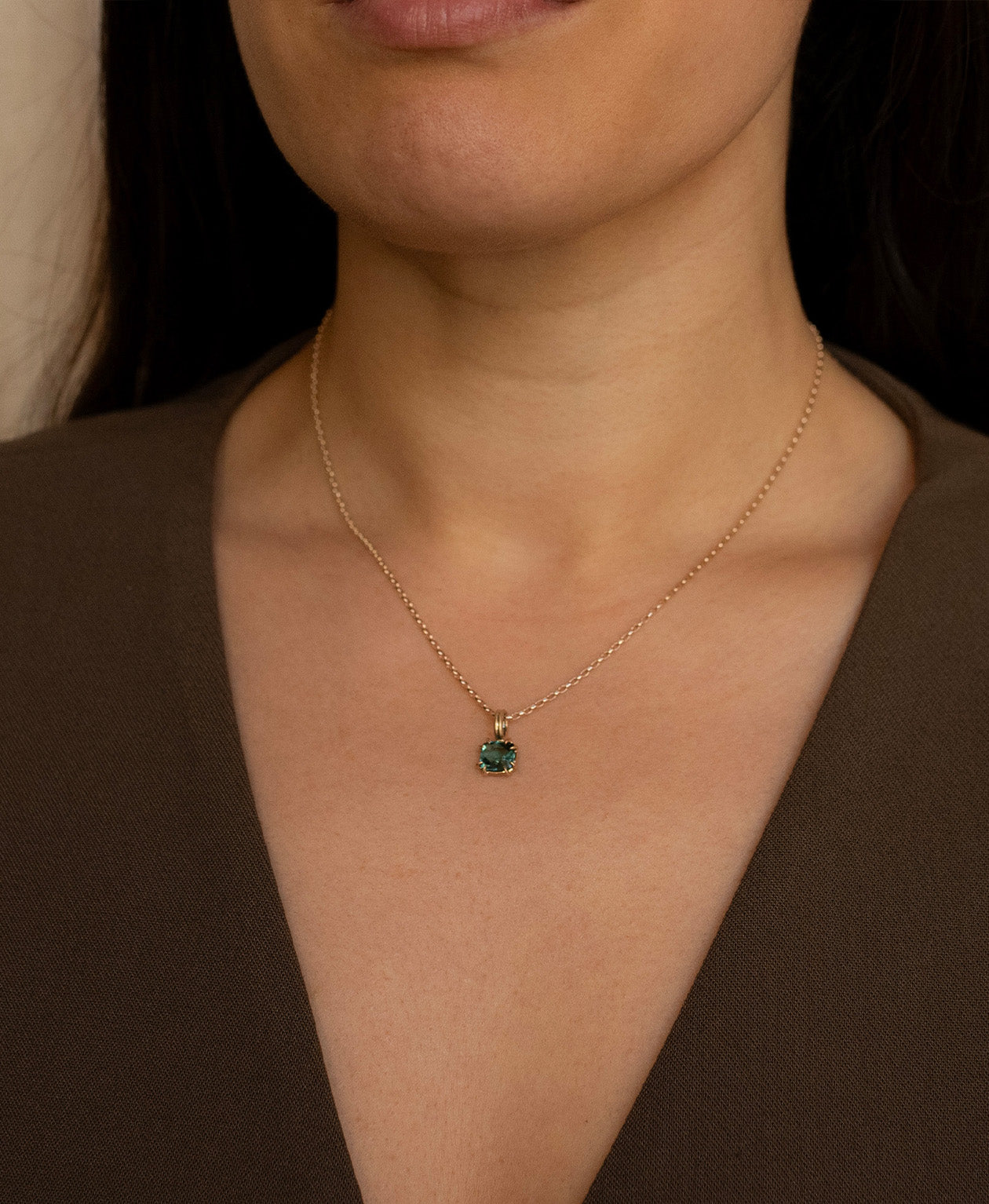 One of a Kind Charm 501 with a teal cushion cut Tourmaline worn by a model on a belcher chain.