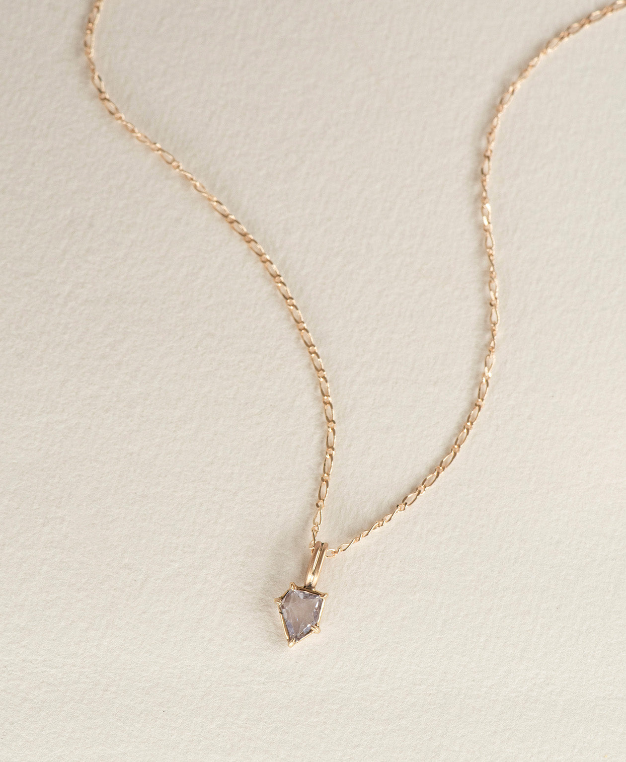 One of a Kind Charm 506 with a light blue portrait cut Sapphire on a figaro chain.