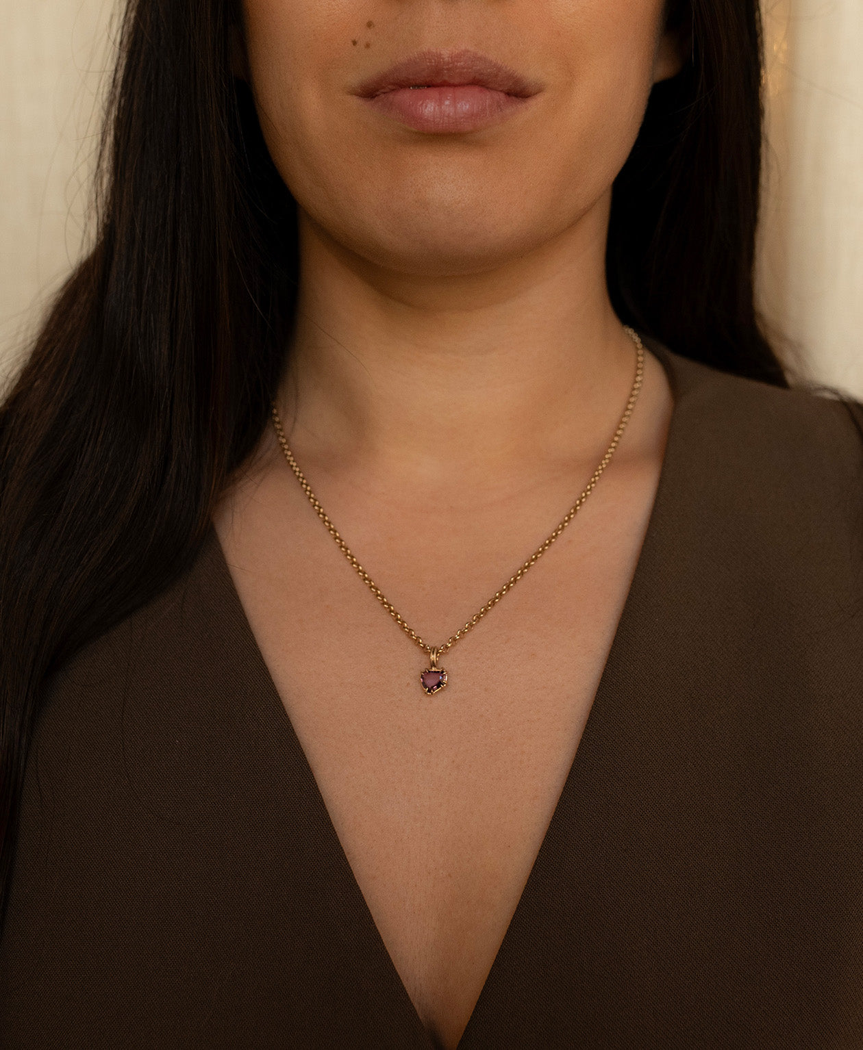 One of a Kind Charm 507 with a deep purple portrait cut Sapphire worn by a model on a belcher chain.