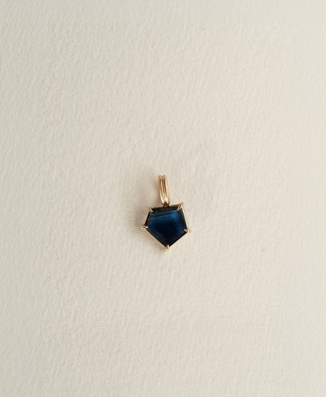 One of a Kind Charm 508 in 9k Yellow Gold featuring a deep blue portrait cut Sapphire with a claw setting.