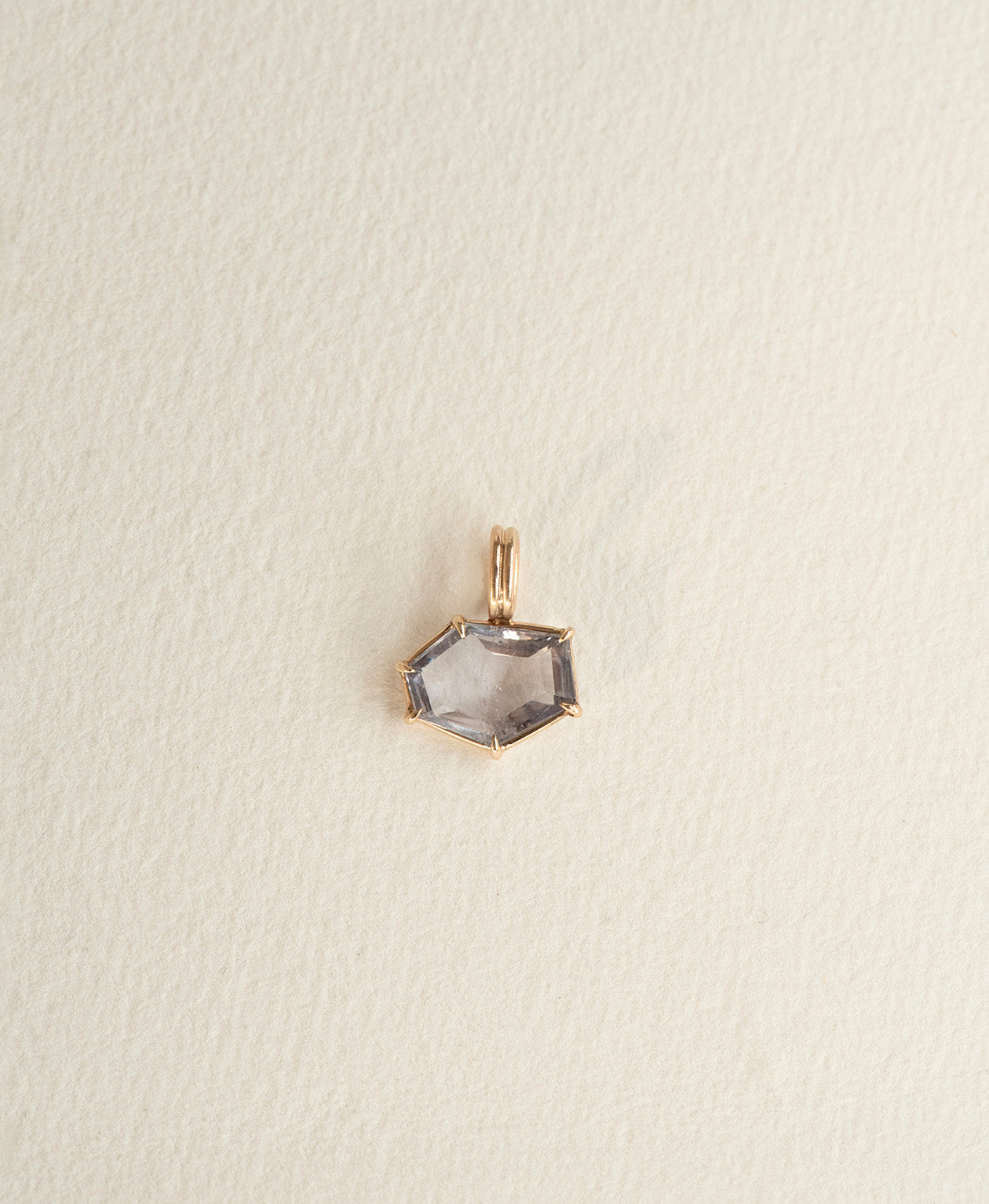 One of a Kind Charm 509 in 9k Yellow Gold featuring a lilac hexagonal cut Sapphire with a claw setting.