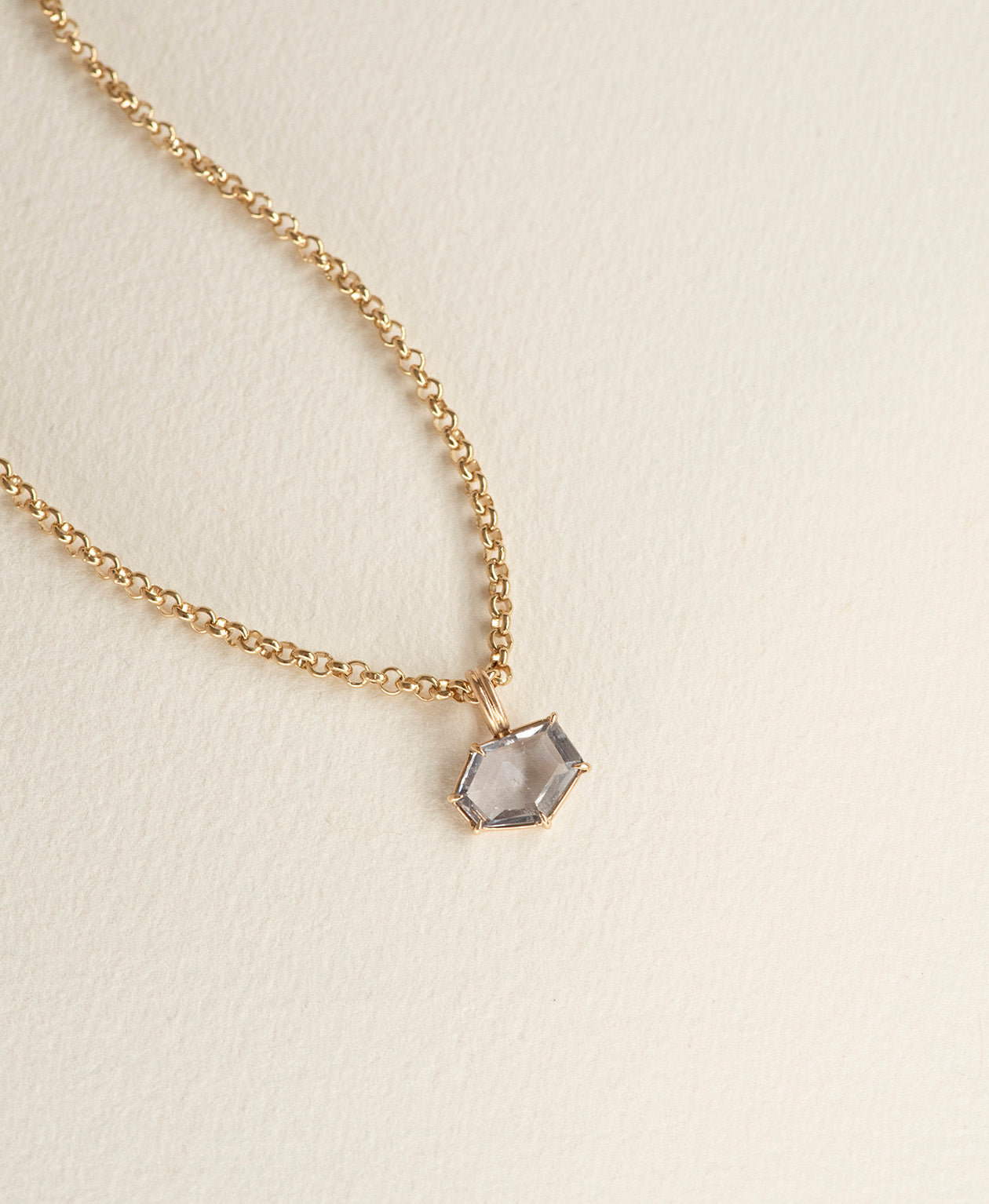 Close up of the One of a Kind Charm 509 with a lilac hexagonal cut Sapphire on a curb chain.