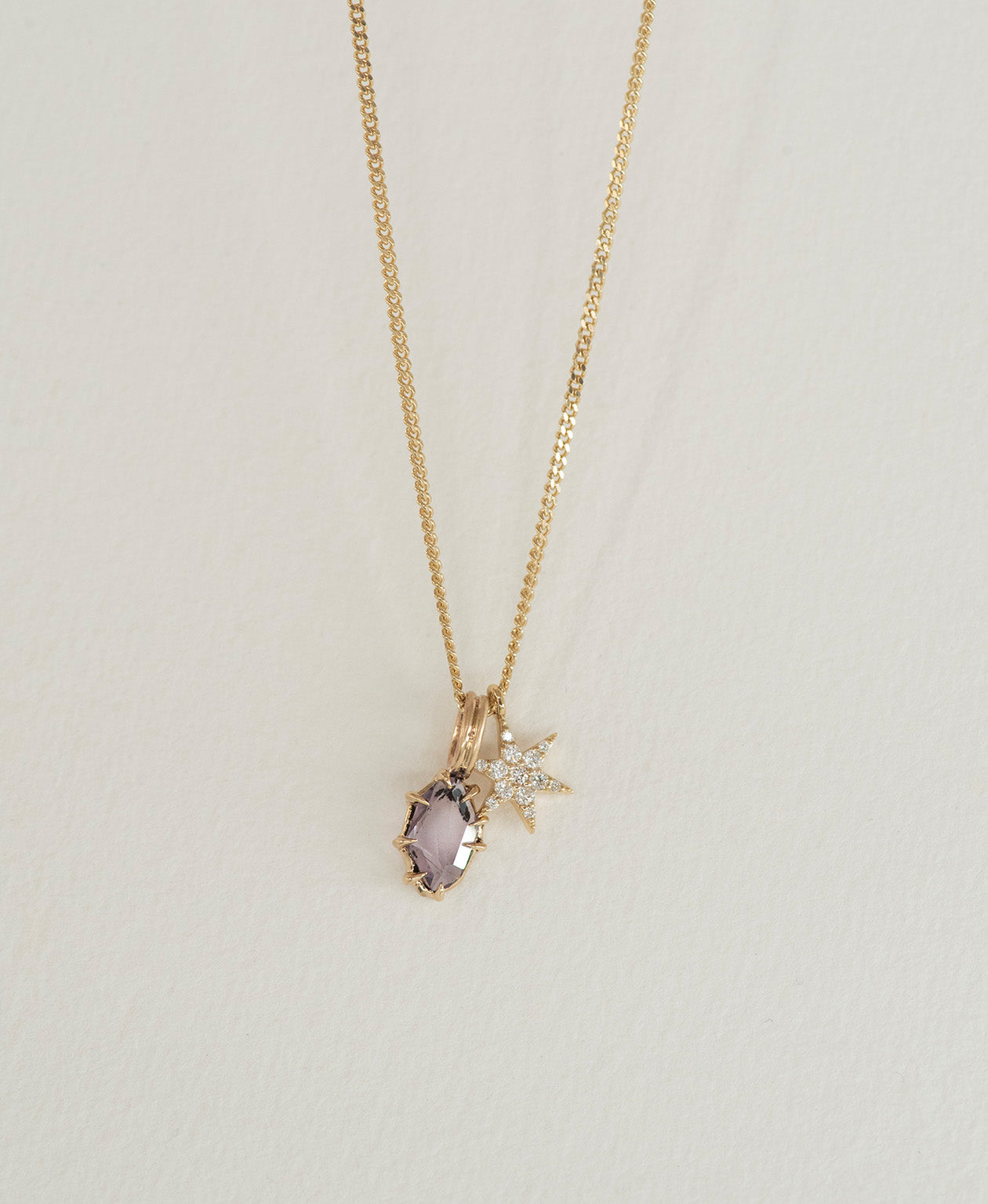 One of a Kind Charm 510 with a purple portrait cut Sapphire, and diamond star pendant on a curb chain.