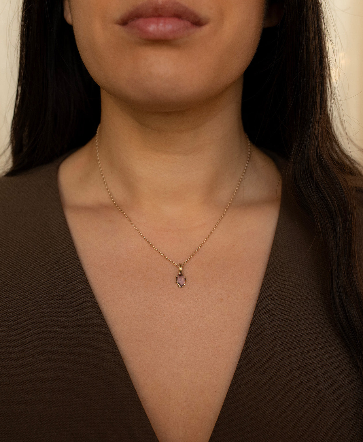 One of a Kind Charm 510 with a purple portrait cut Sapphire worn by a model on a fine belcher chain.