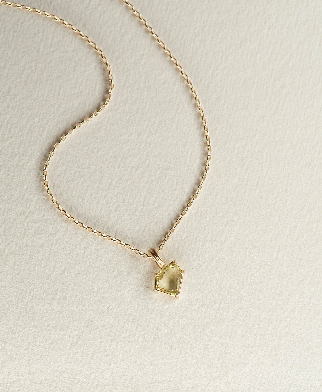 One of a Kind Charm 514 with a light yellow portrait cut Sapphire on a fine belcher chain.