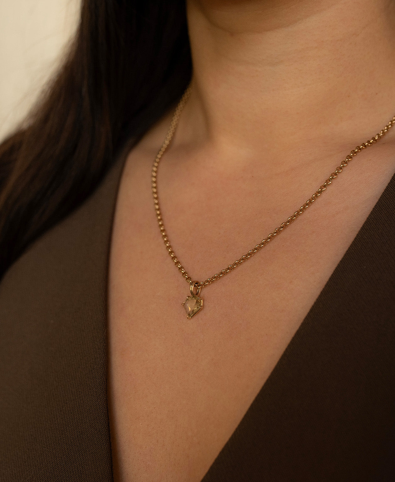 Close up of the One of a Kind Charm 514 with a light yellow portrait cut Sapphire worn by a model on a belcher chain.