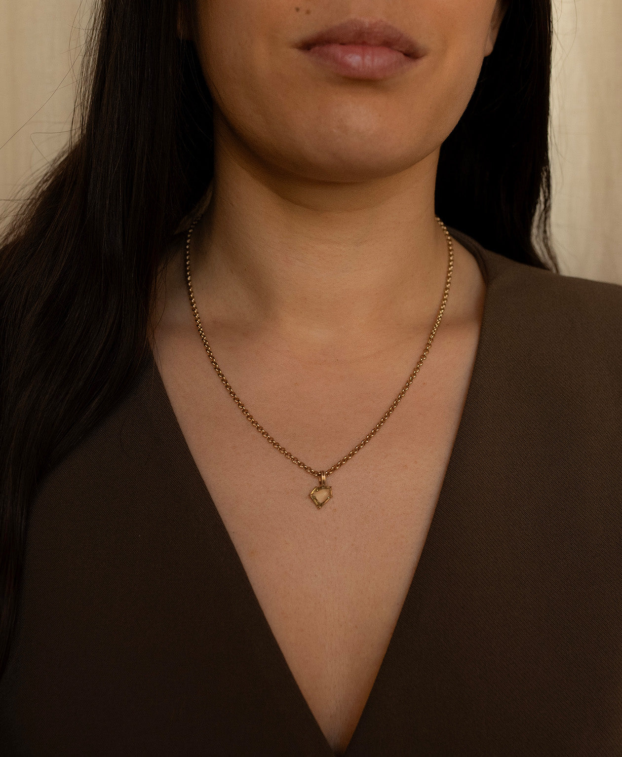 One of a Kind Charm 514 with a light yellow portrait cut Sapphire worn by a model on a belcher chain.