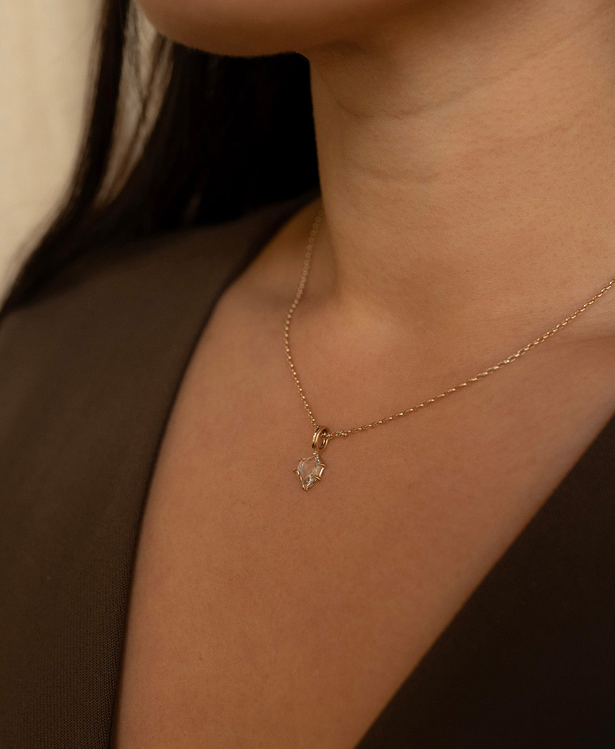 Close up of the One of a Kind Charm 516 with a white portrait cut Sapphire worn by a model on a fine belcher chain.