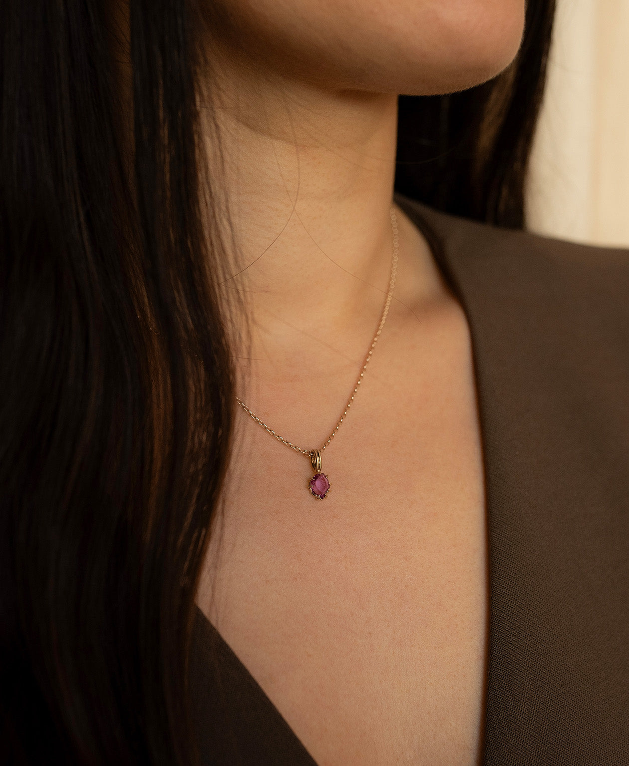 Close up of the One of a Kind Charm 517 with a pale purple portrait cut Sapphire worn by a model on a fine belcher chain.