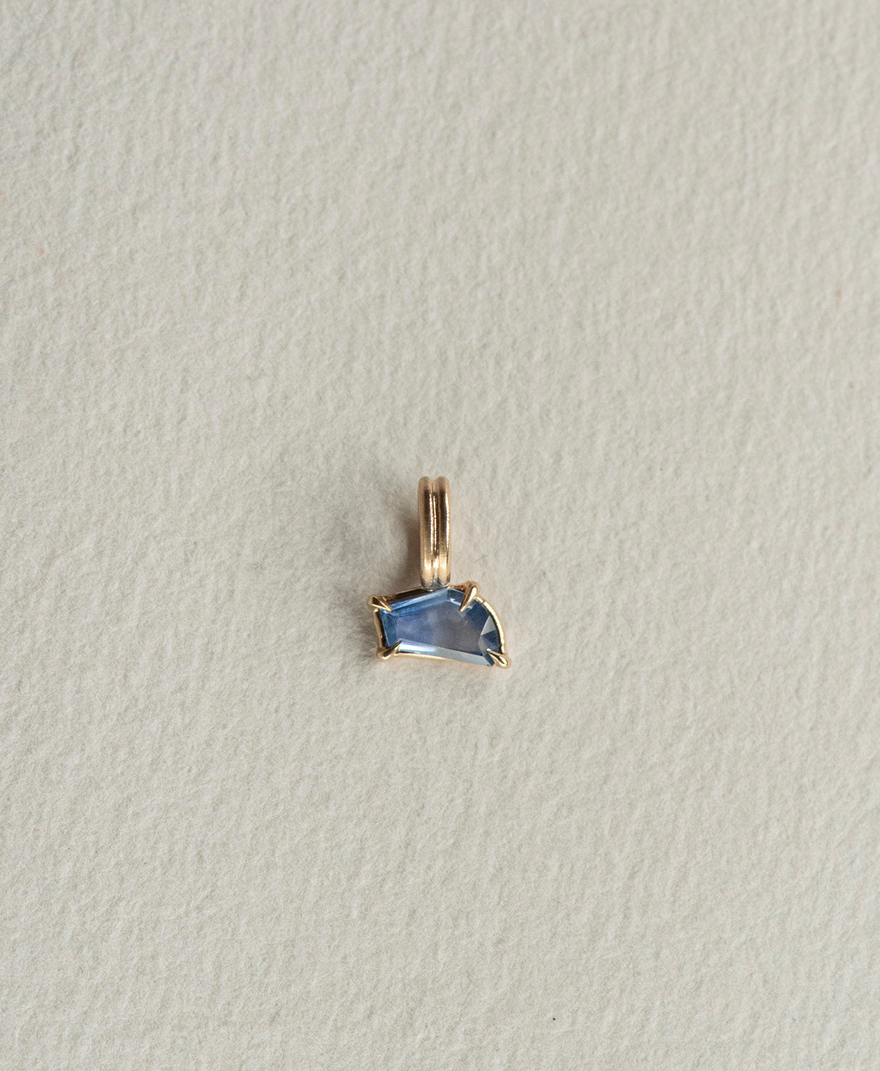 One of a Kind Charm 519 in 9k Yellow Gold featuring a blue fancy cut Sapphire with a claw setting.