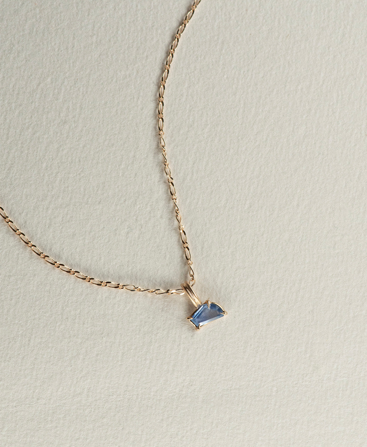 One of a Kind Charm 519 with a blue fancy cut Sapphire on a fine figaro chain.