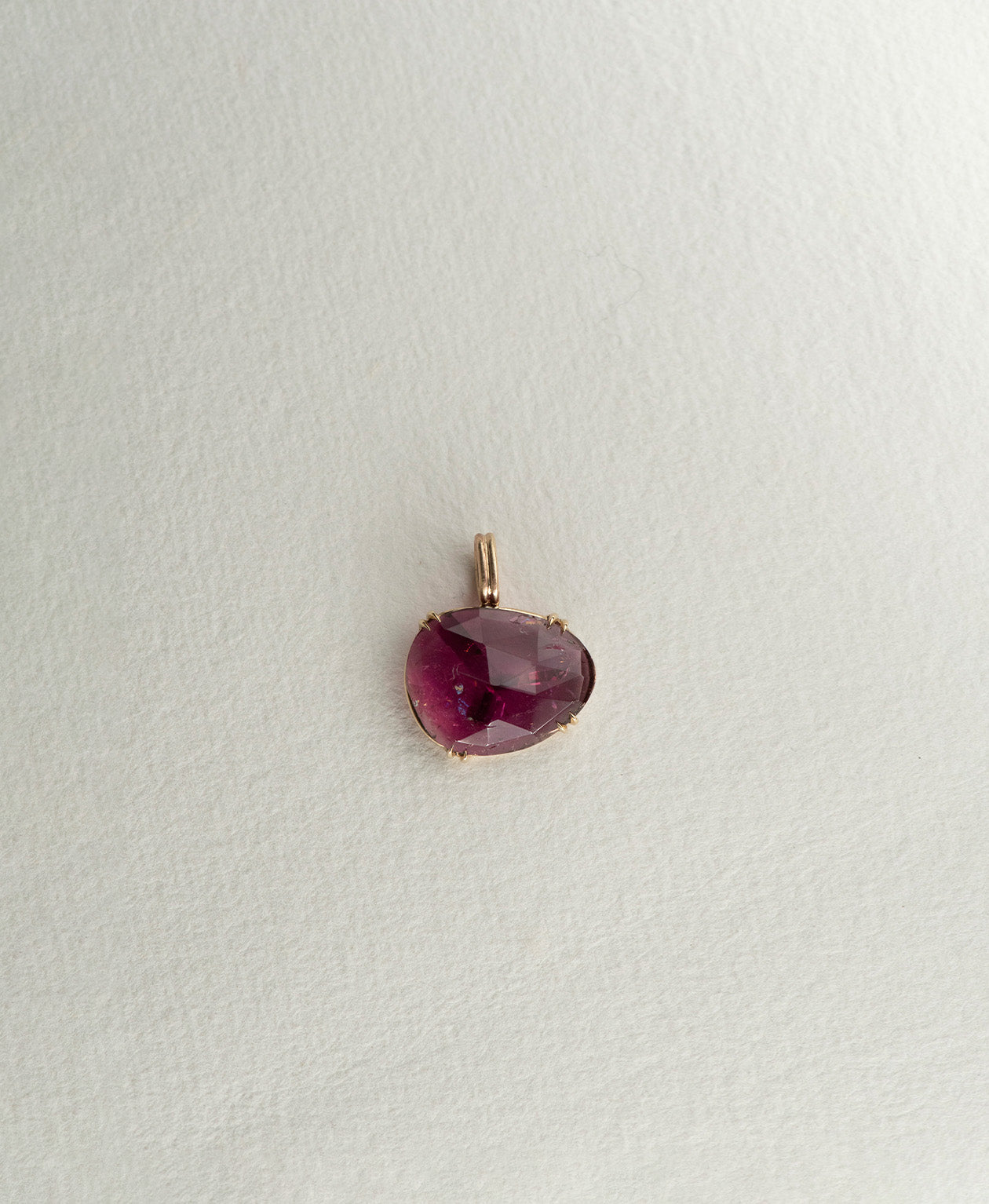 One of a Kind Charm 492 in 9k Yellow Gold featuring a rose cut pink tourmaline, with a double claw setting.