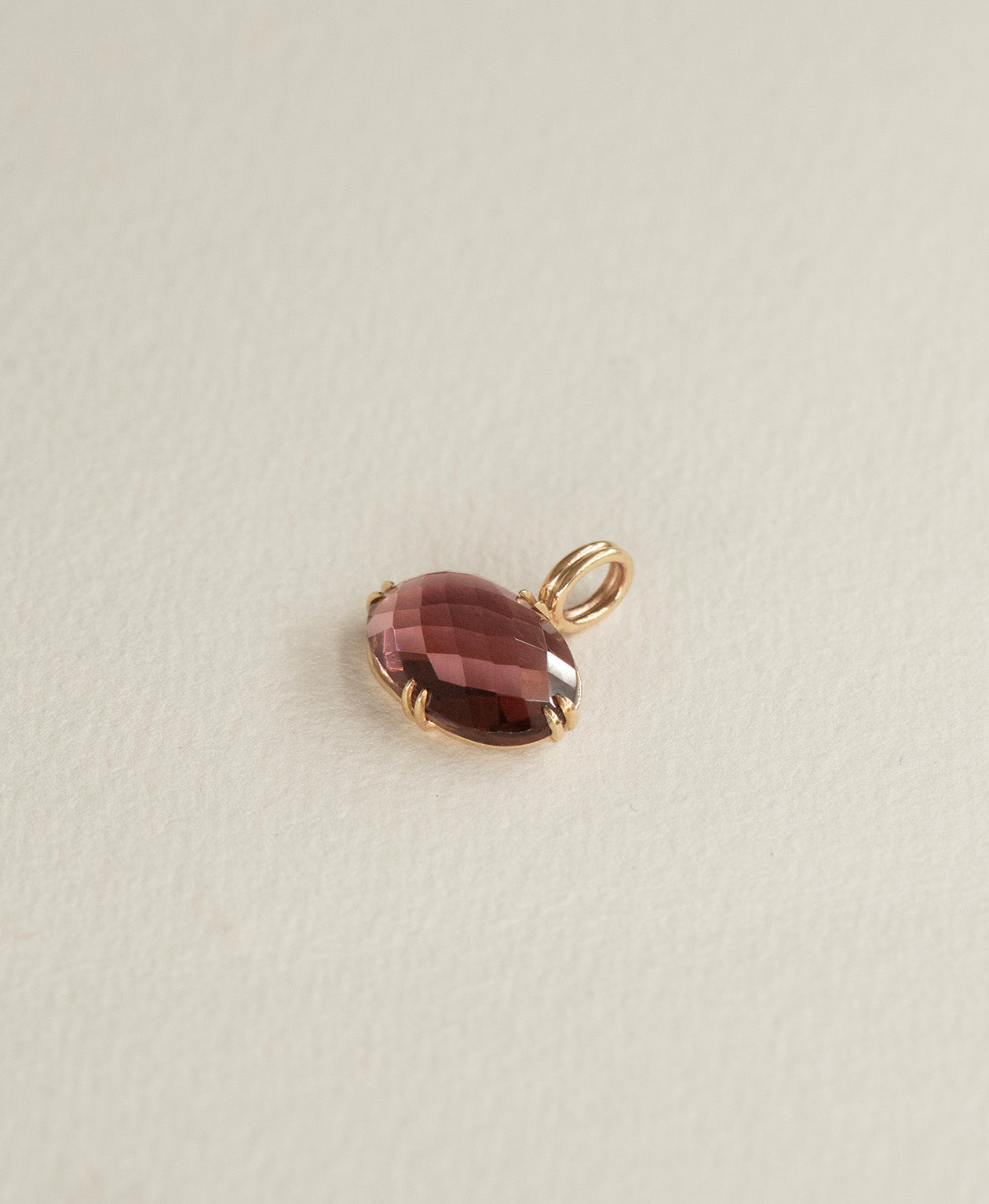 Angled view of the One of a Kind Charm 493 in 9k Yellow Gold with a checkerboard cut fuchsia pink tourmaline.