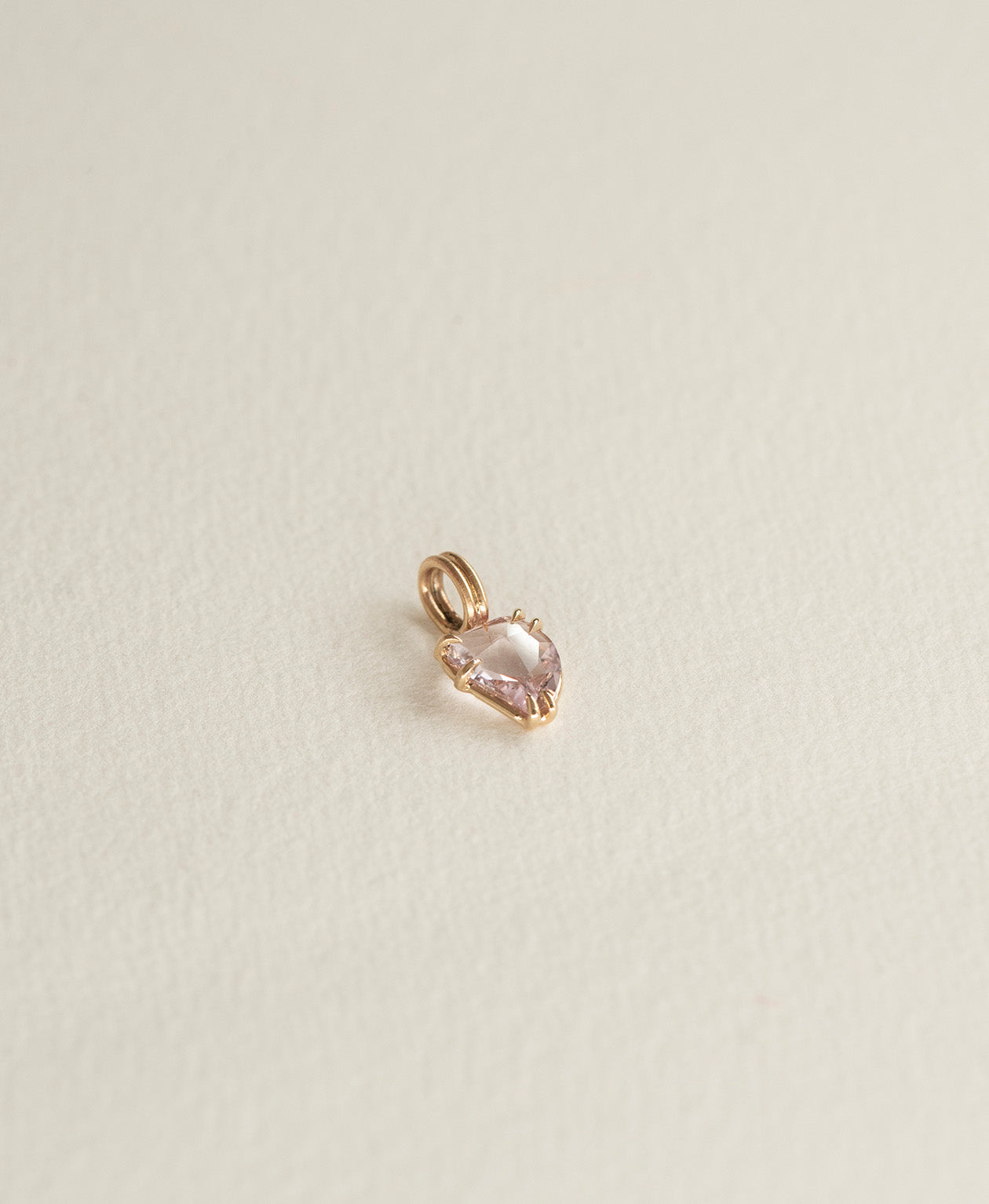 Side angle view of One of a Kind Charm 499 in 9k Yellow Gold with a light pink rose cut Sapphire.