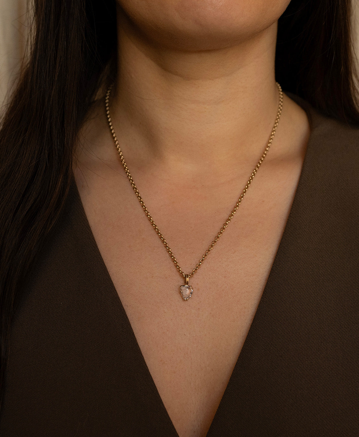 Close up of the One of a Kind Charm 499 with a light pink rose cut Sapphire worn by a model on a belcher chain. 