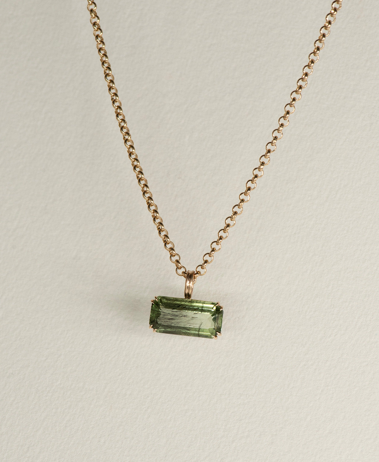 Close up of the One of a Kind Charm 502 with a deep green emerald cut Peridot on a belcher chain.
