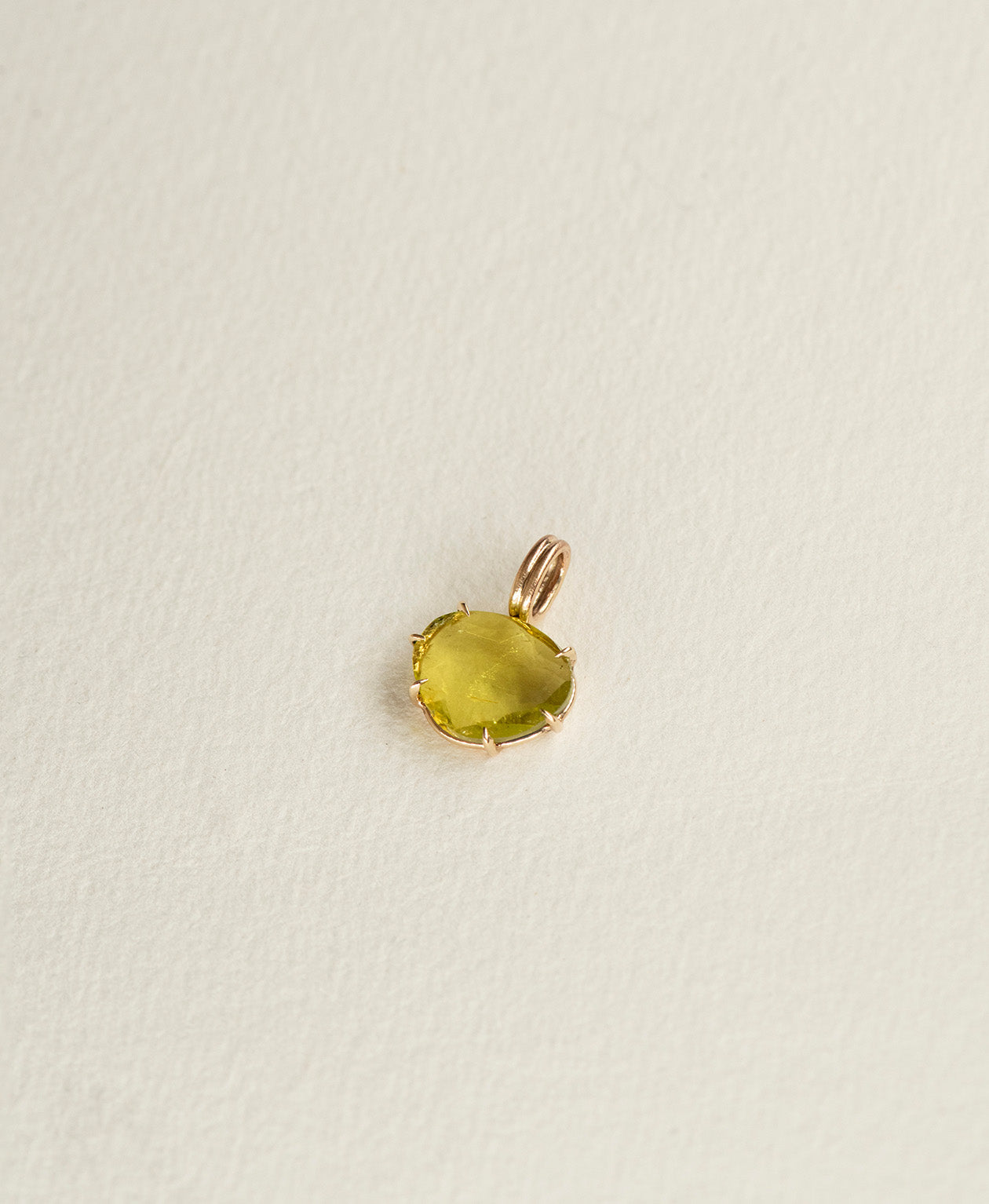 Angled view of the One of a Kind Charm 503 in 9k Yellow Gold with a rose cut green Tourmaline.