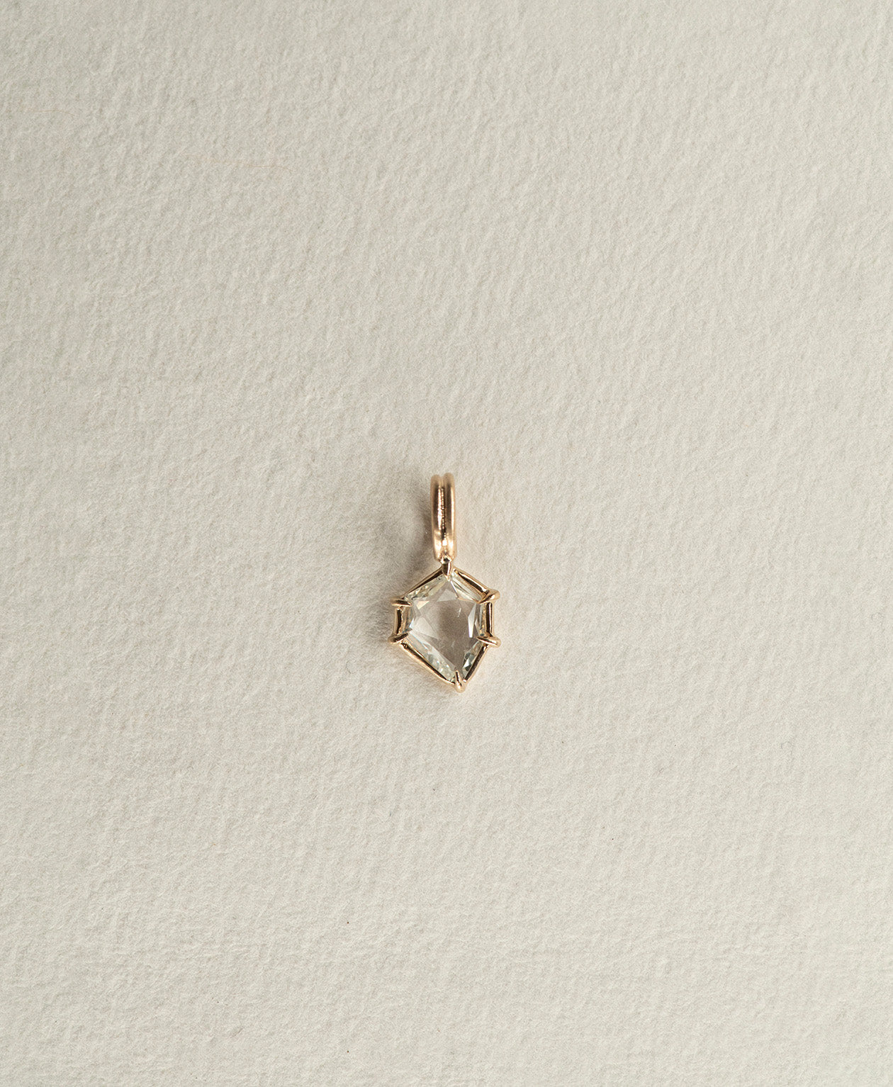 One of a Kind Charm 516 in 9k Yellow Gold featuring a white portrait cut Sapphire with a claw setting.