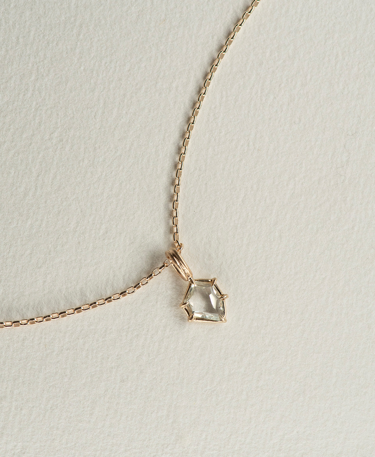 One of a Kind Charm 516 with a white portrait cut Sapphire worn by a model on a fine belcher chain.